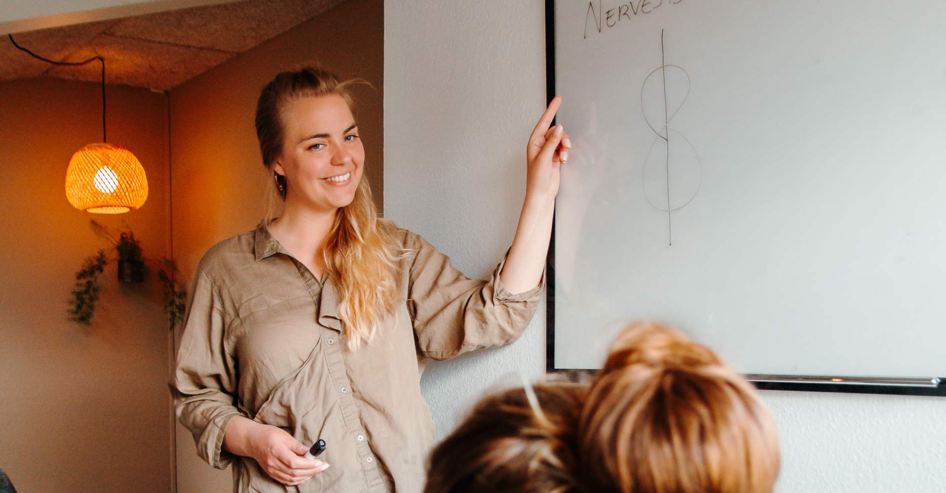 Sigrid underviser ved whiteboardet om nervesystemet